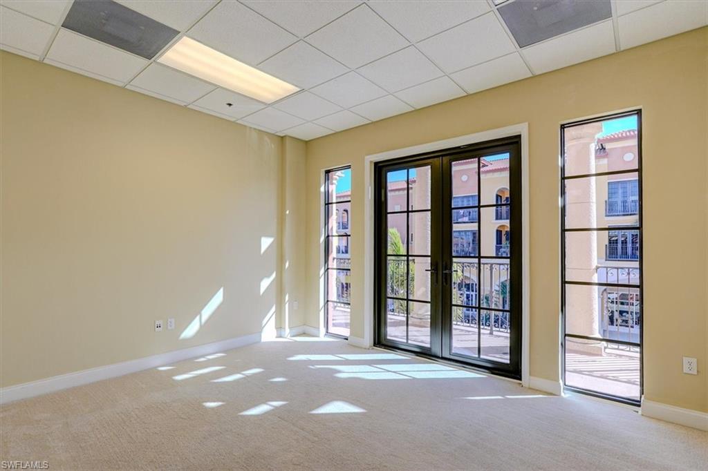 Empty room with light carpet, french doors, and a paneled ceiling