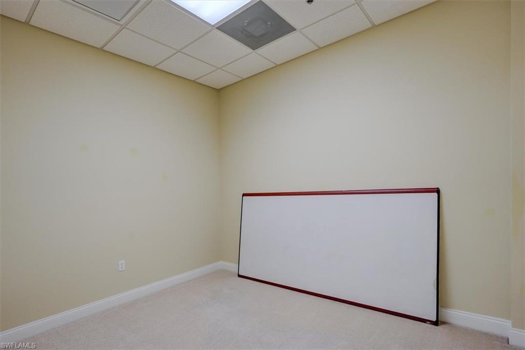 Office with a drop ceiling and carpet flooring