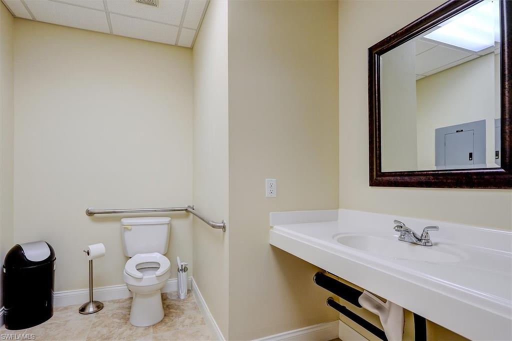Bathroom with a paneled ceiling and light tile patterned flooring
