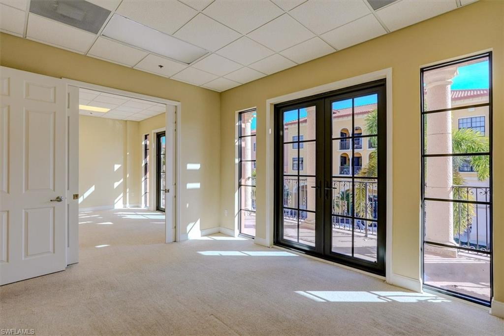 Office with a drop ceiling, carpet, and french doors
