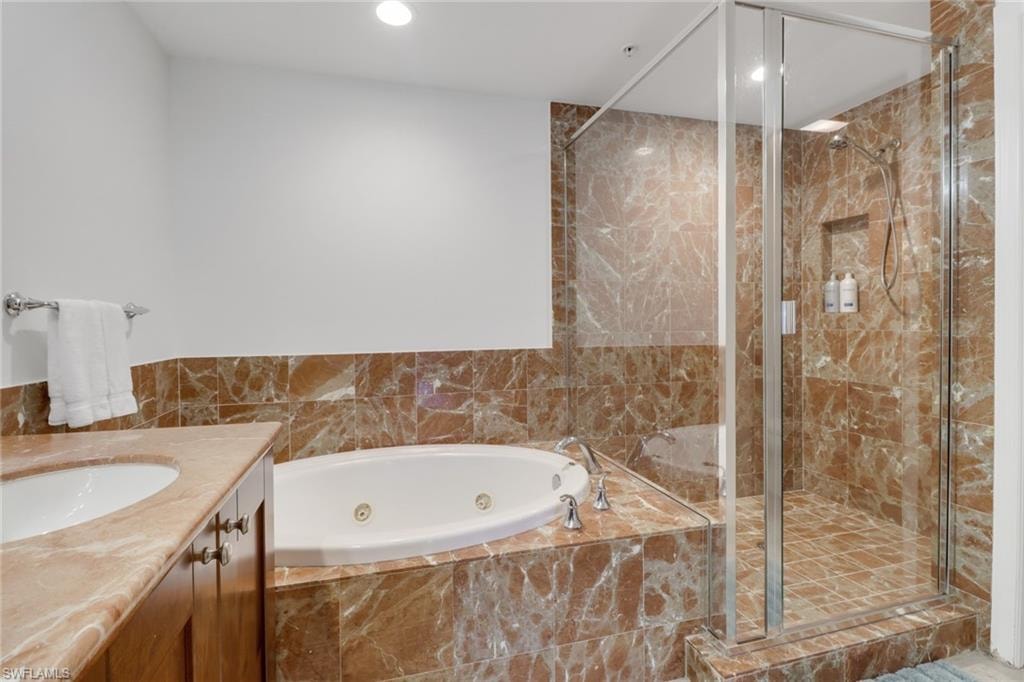 Bathroom featuring independent shower and bath and vanity
