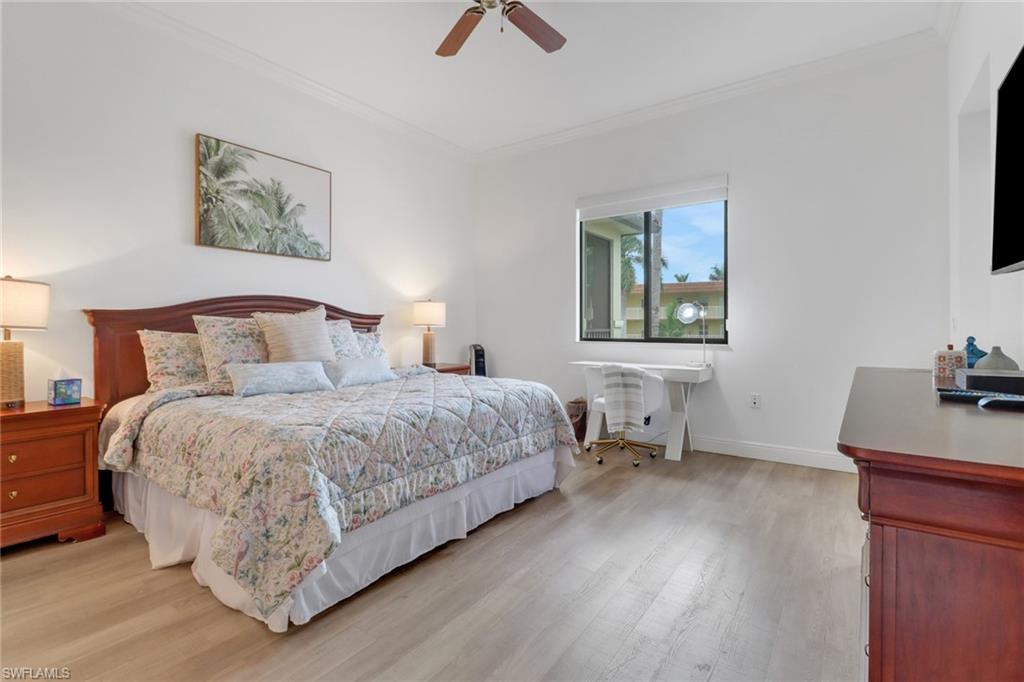 Bedroom featuring ceiling fan, crown molding, and light wood-type flooring