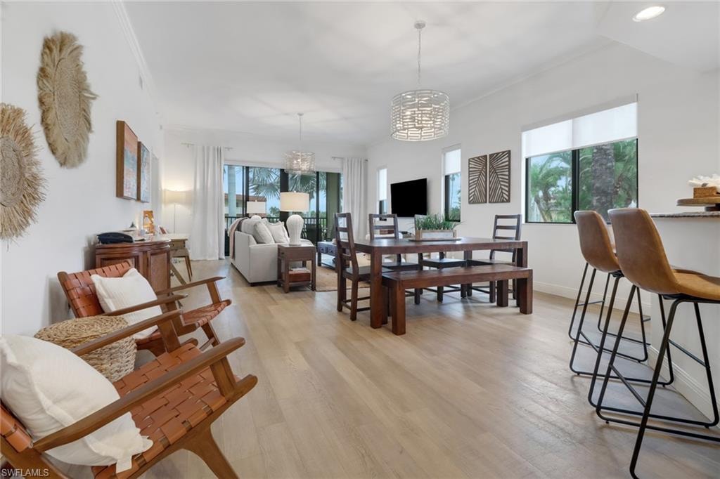 Dining room with light hardwood / wood-style floors and an inviting chandelier