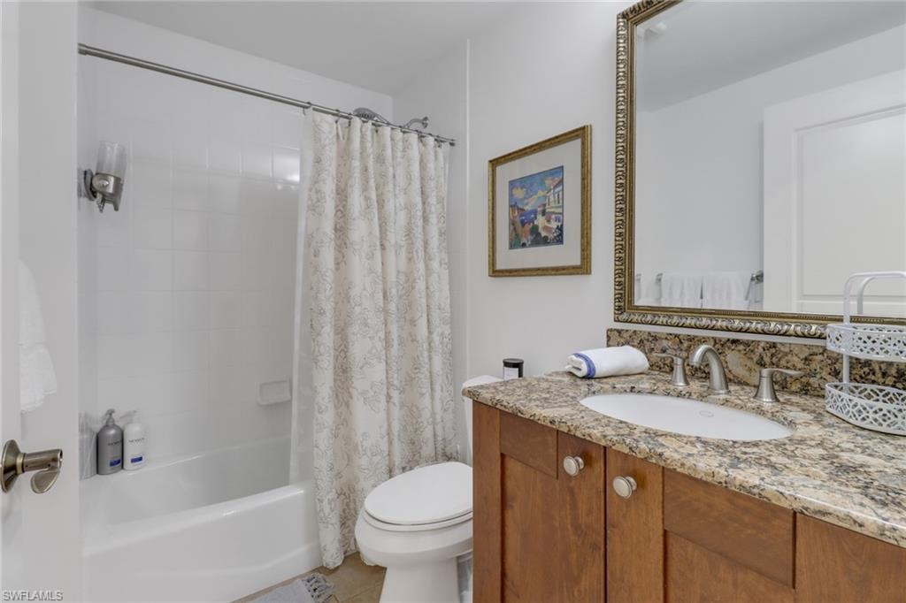 Full bathroom featuring toilet, vanity, tile patterned floors, and shower / tub combo with curtain
