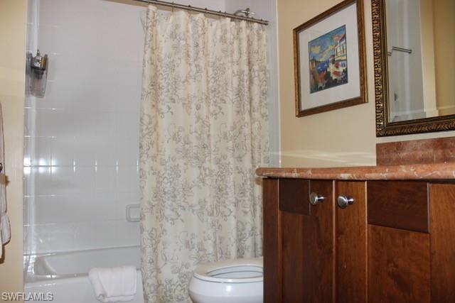 Full bathroom featuring vanity, shower / bath combination with curtain, and toilet