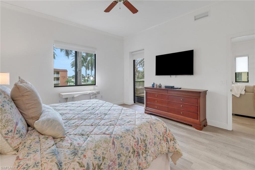 Bedroom with light wood-type flooring, ceiling fan, and ornamental molding