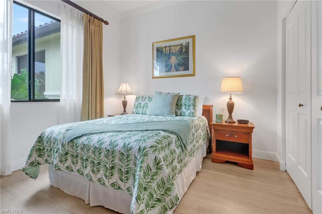 Bedroom with light wood-type flooring, a closet, and ornamental molding