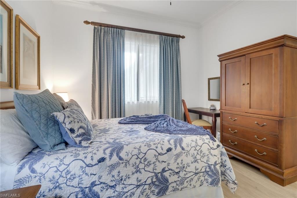 Bedroom with ornamental molding and light wood-type flooring