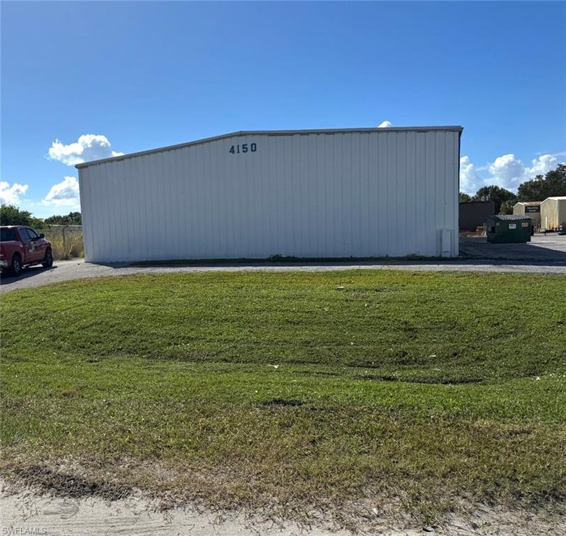 View of pole building with a yard