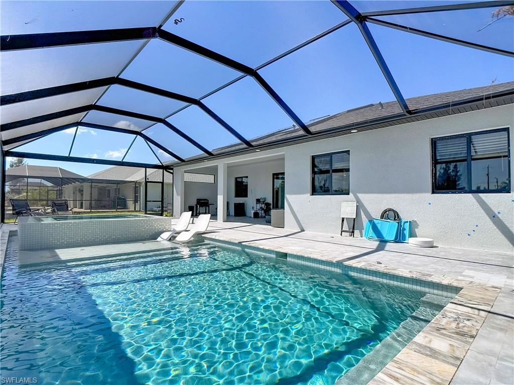 Integrated pool / spa with a sunroom, a patio area, and glass enclosure