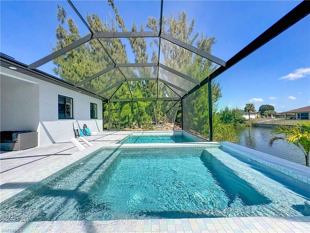 Integrated pool / spa with a sunroom, a lanai, a water view, and a patio area