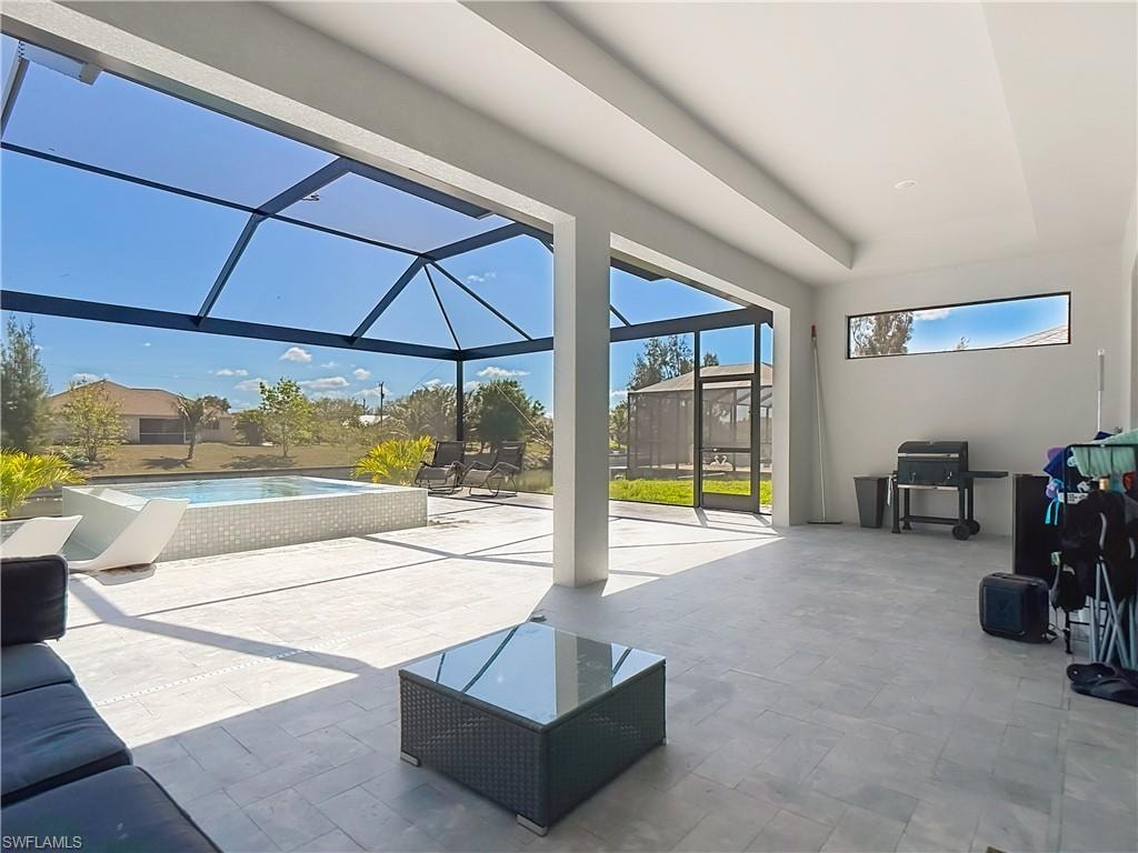 View of patio featuring a sunroom, a lanai, an outdoor pool, and area for grilling