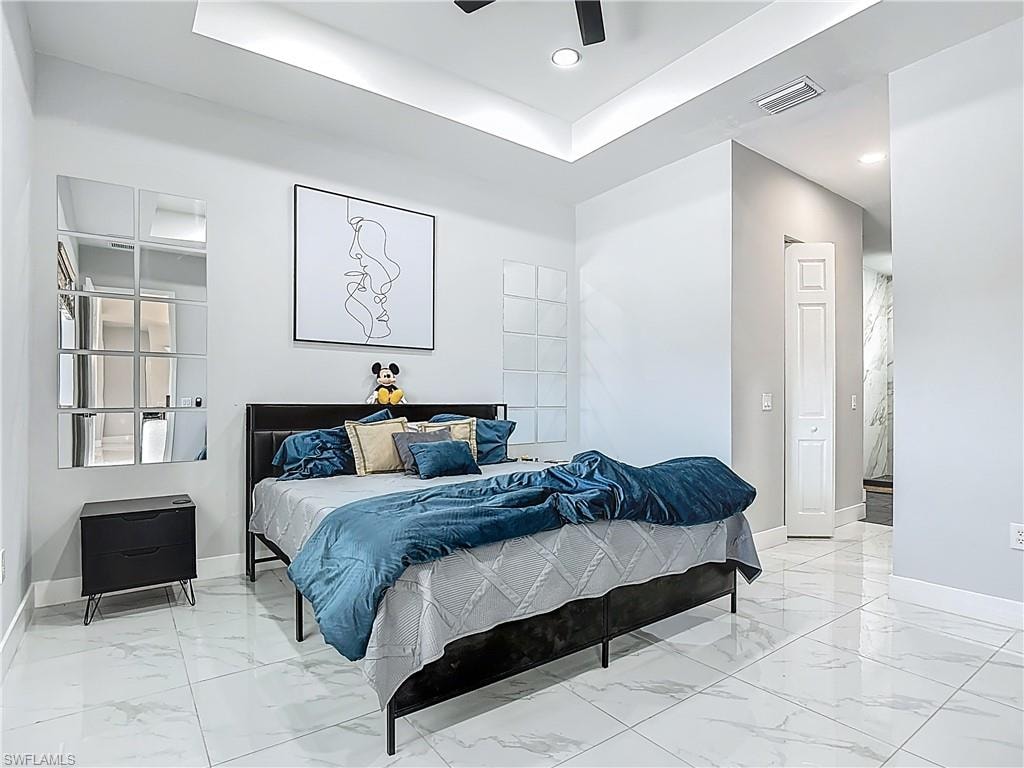 Bedroom featuring a tray ceiling, a ceiling fan, and recessed lighting