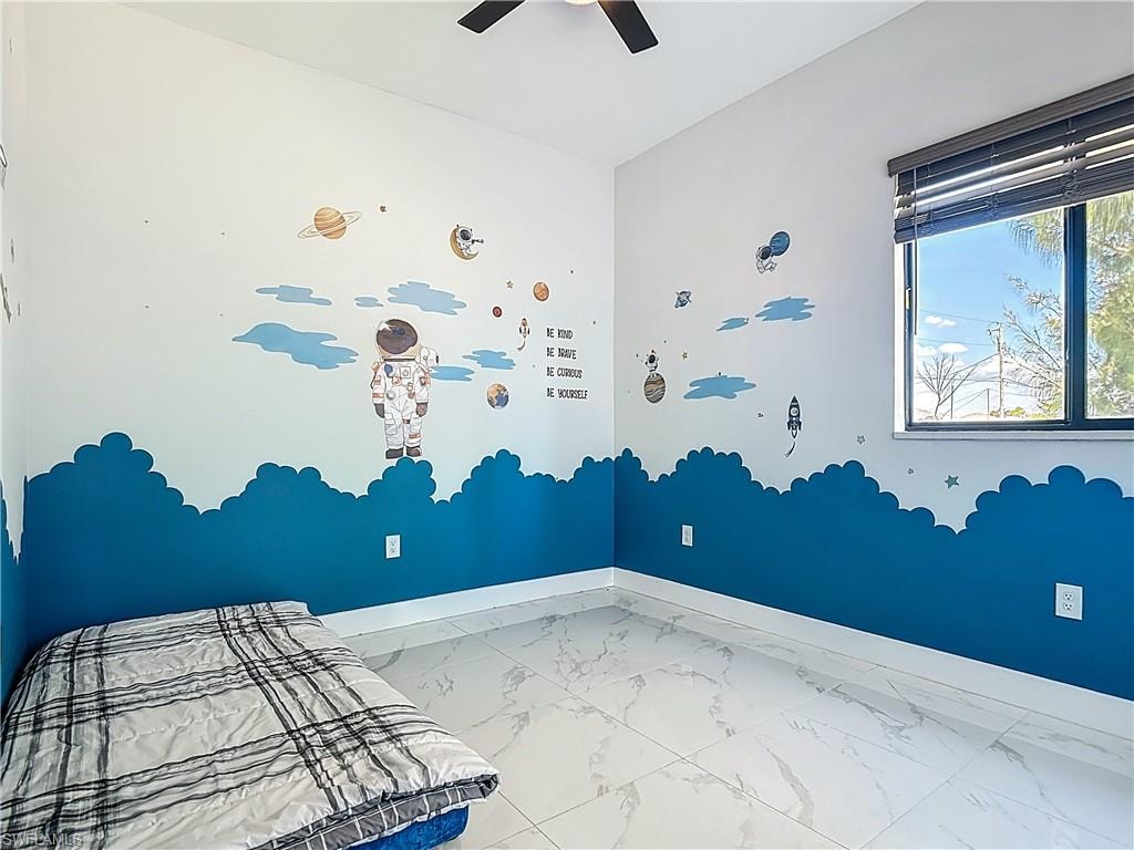 Unfurnished bedroom with light marble finish floors and ceiling fan