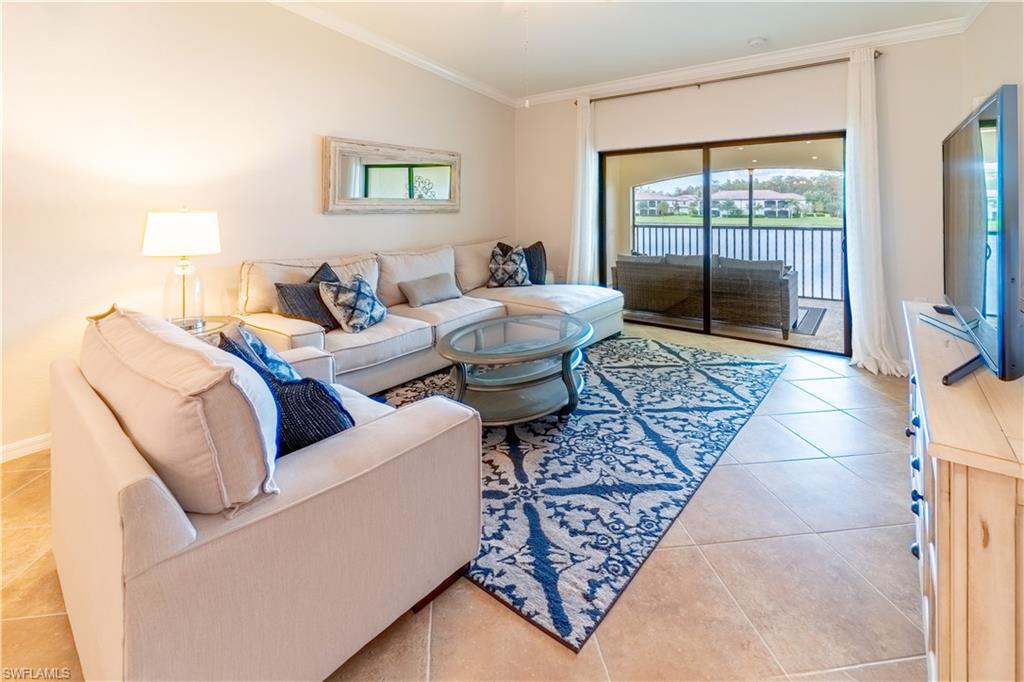 Tiled living room with crown molding and vaulted ceiling