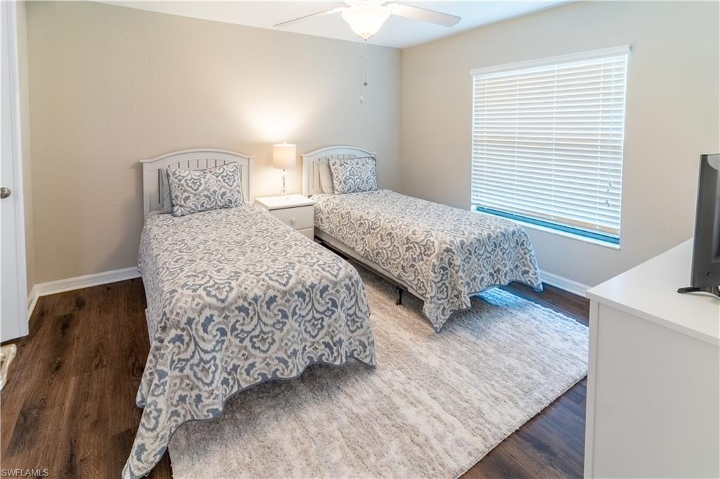 Bedroom with dark hardwood / wood-style flooring and ceiling fan