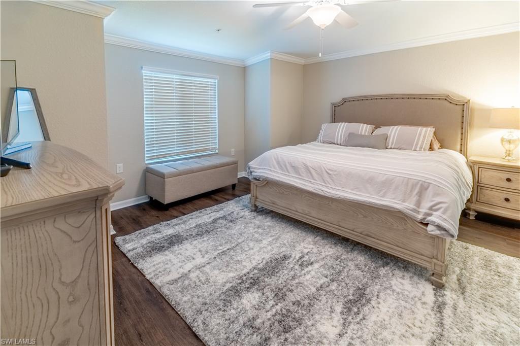 Bedroom with crown molding, ceiling fan, and dark hardwood / wood-style flooring
