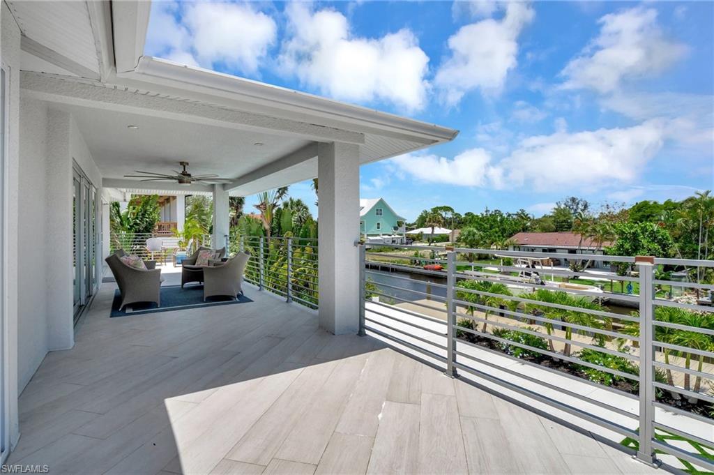 Wooden terrace with a patio, a ceiling fan, and a water view