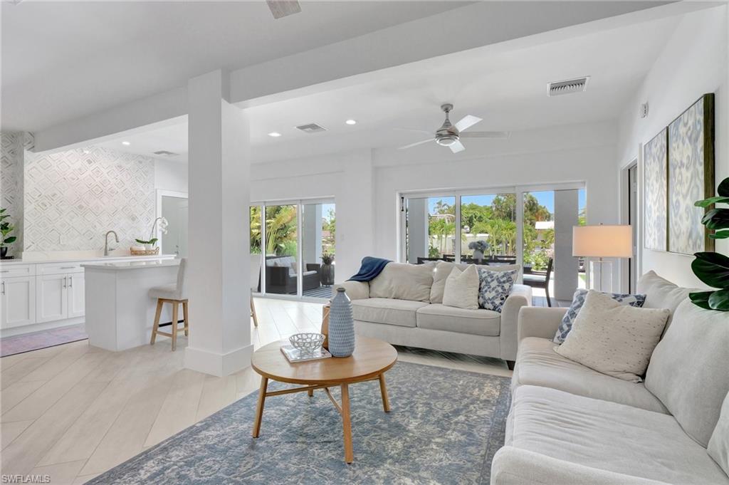 Living area with ceiling fan, recessed lighting, and light wood-style flooring
