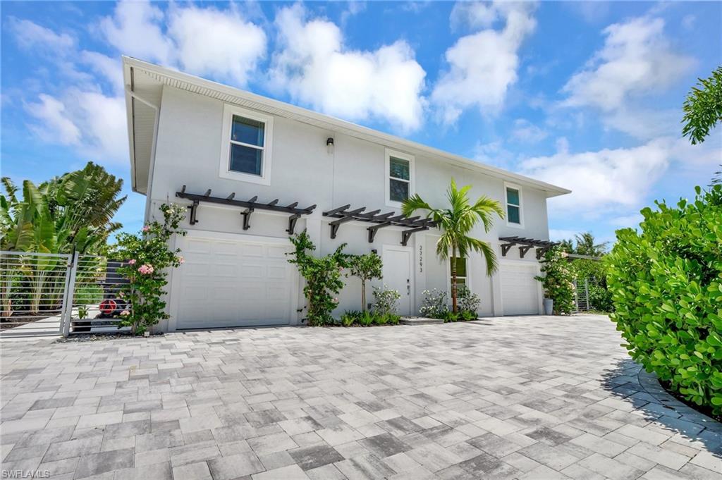 View of front of property featuring a garage, stucco siding, and driveway