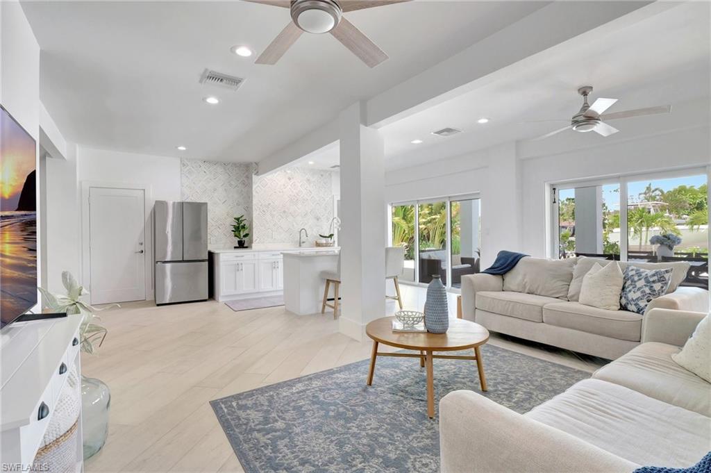 Living area featuring a ceiling fan, recessed lighting, and light wood-type flooring