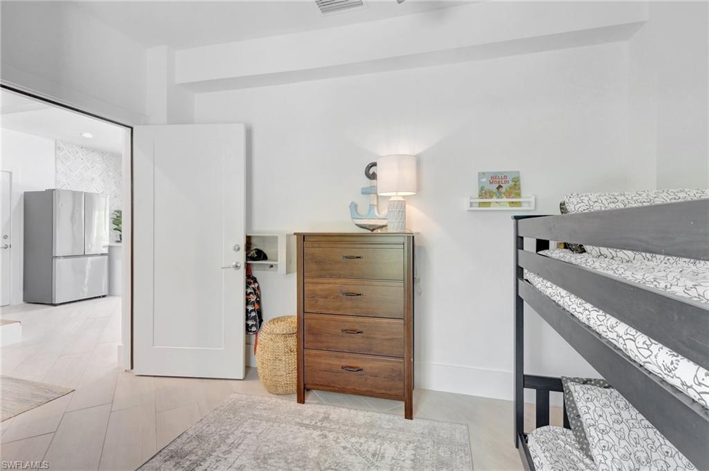 Bedroom featuring freestanding refrigerator and baseboards