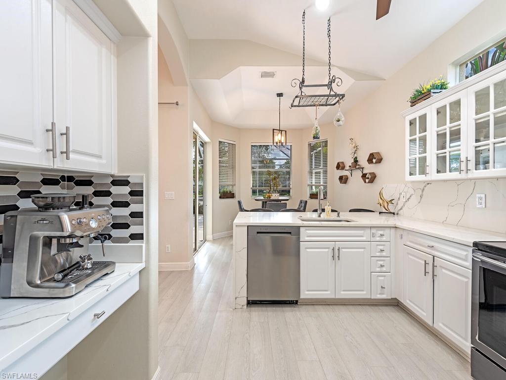 Kitchen featuring white cabinetry, light wood-finish flooring, and light countertops with veining