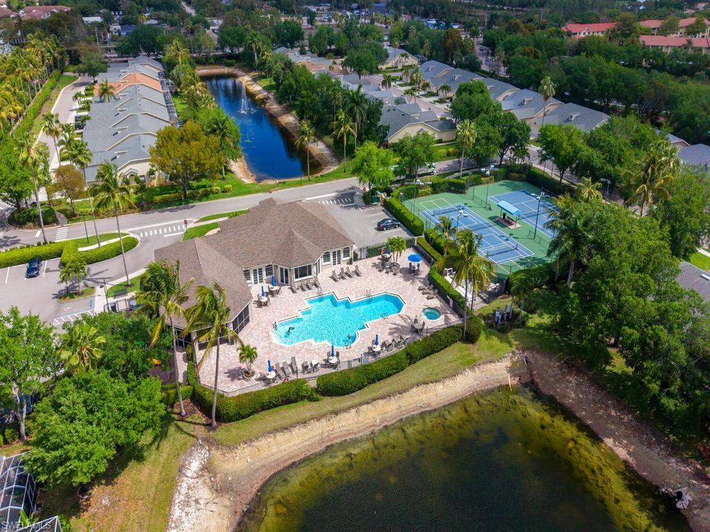 Community amenities featuring a central clubhouse, freeform swimming pool, and adjacent tennis courts