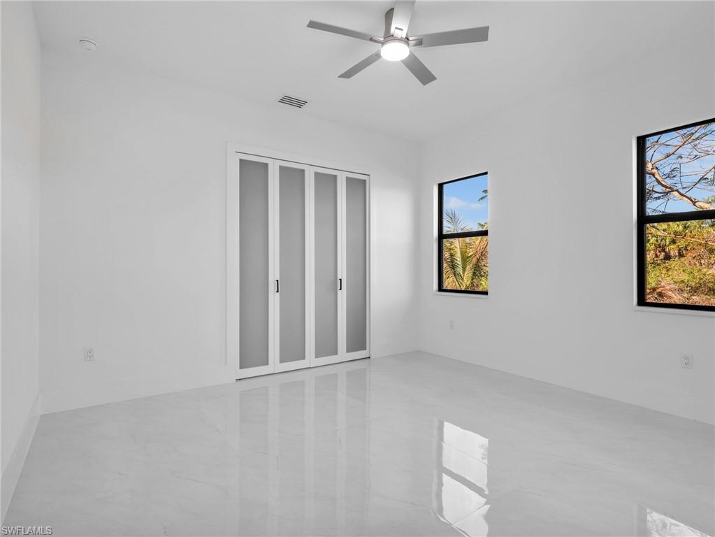Unfurnished bedroom with ceiling fan and a closet