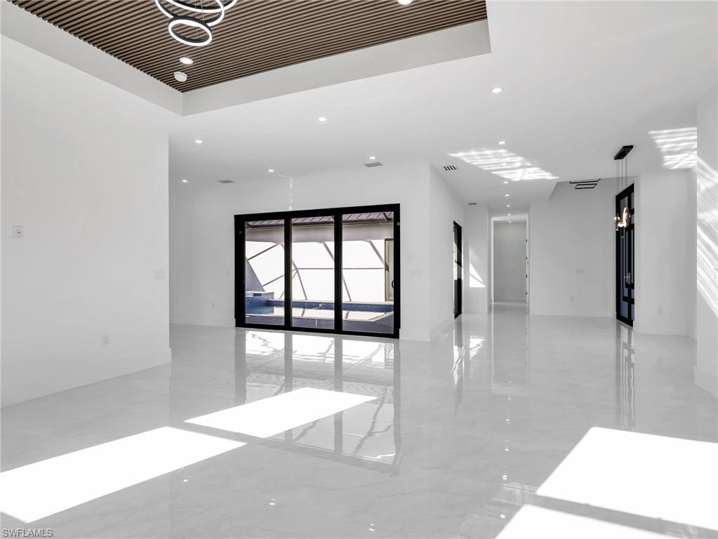 Empty room featuring light marble finish floors and recessed lighting