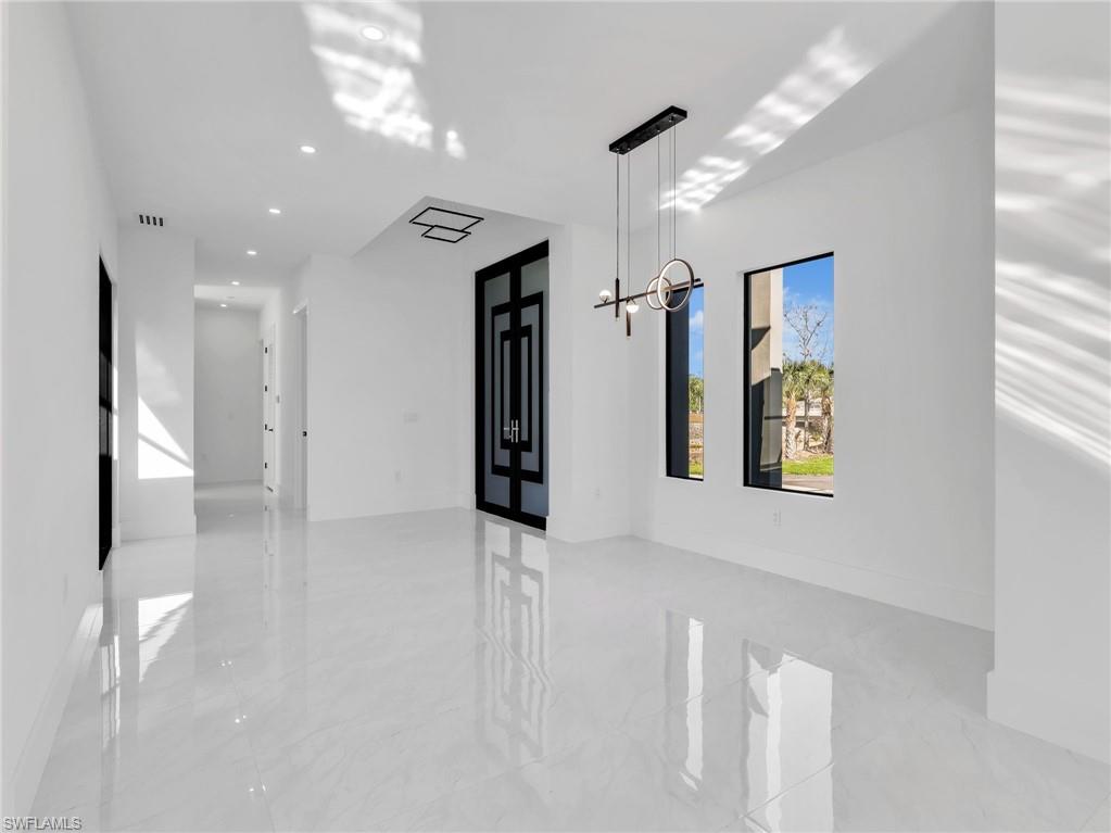 Hall with french doors and a chandelier