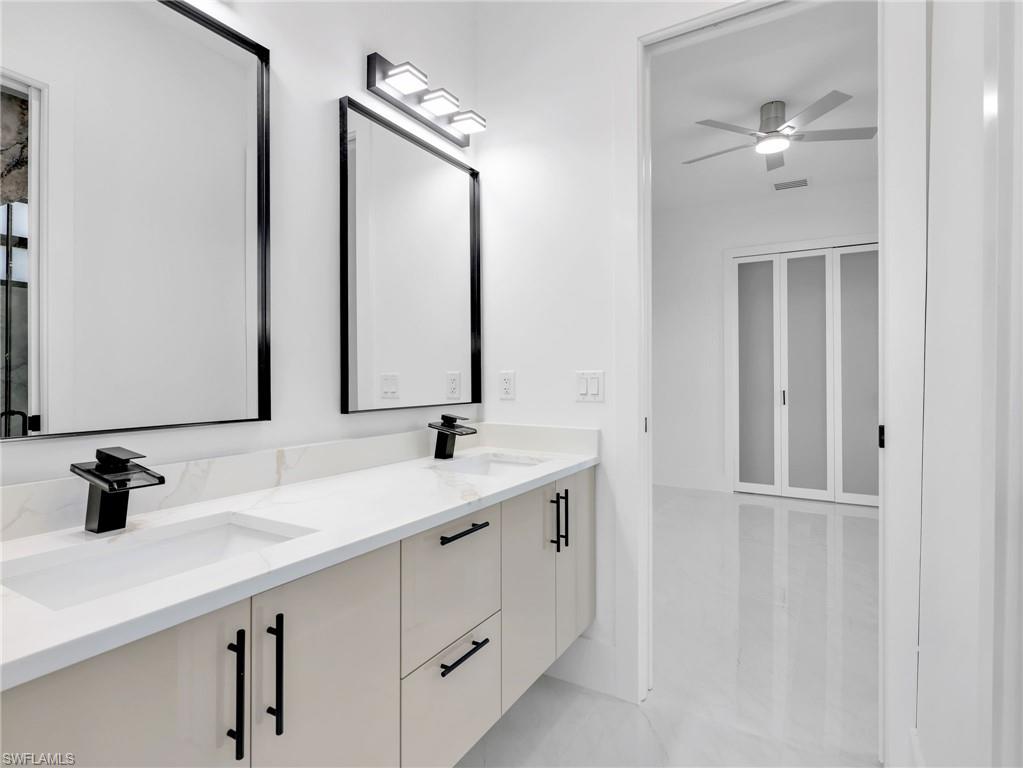 Bathroom featuring double vanity and ceiling fan