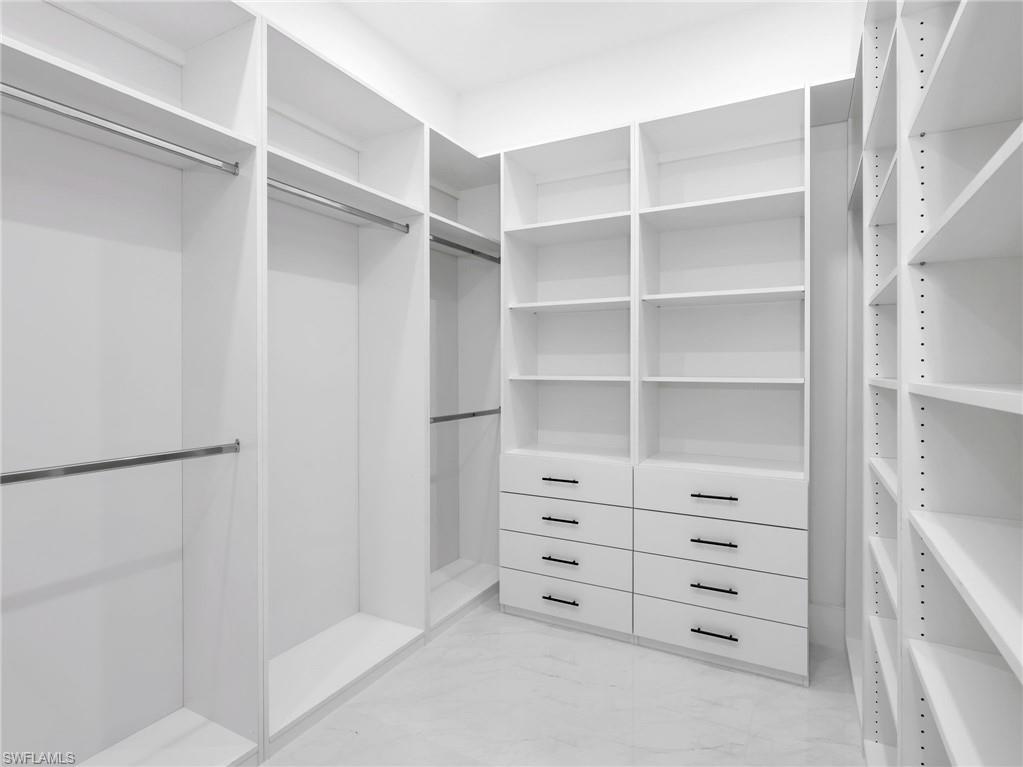 Walk in closet featuring light marble finish floors