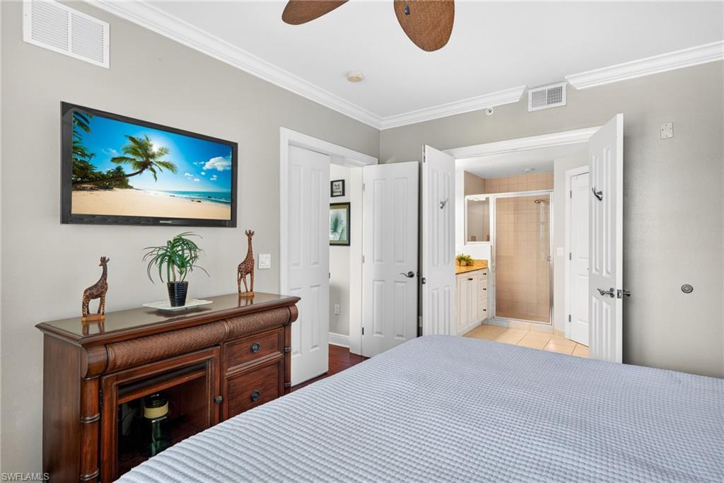 Bedroom featuring crown molding, connected bathroom, a ceiling fan, and light tile patterned flooring