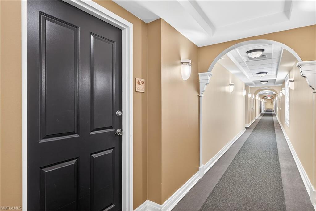 Hallway with dark carpet and arched walkways