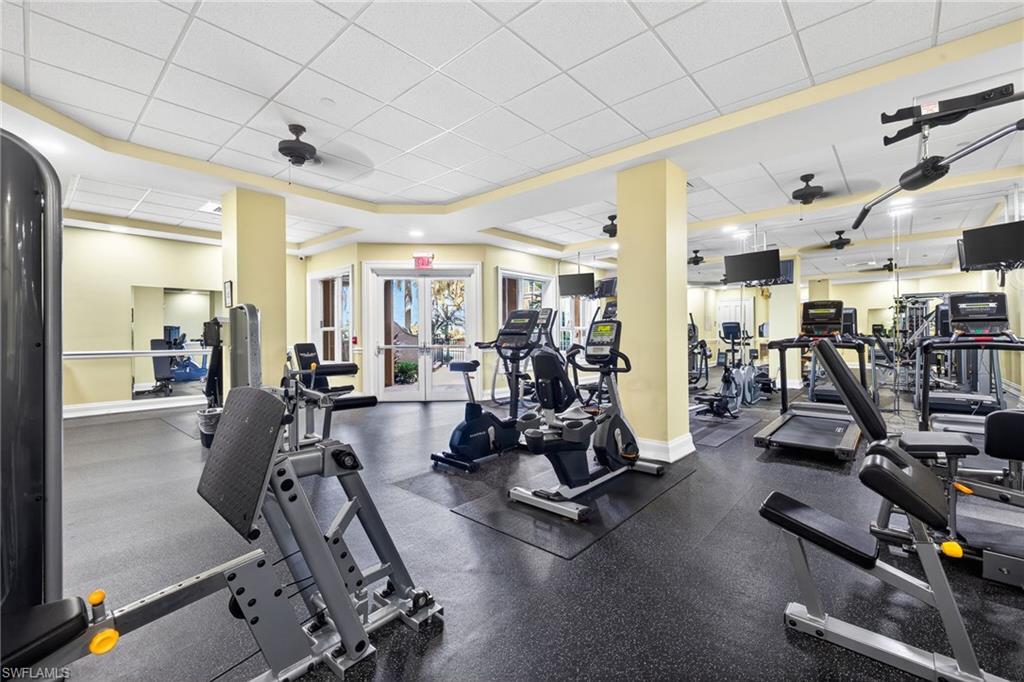 Workout area featuring a ceiling fan and a paneled ceiling