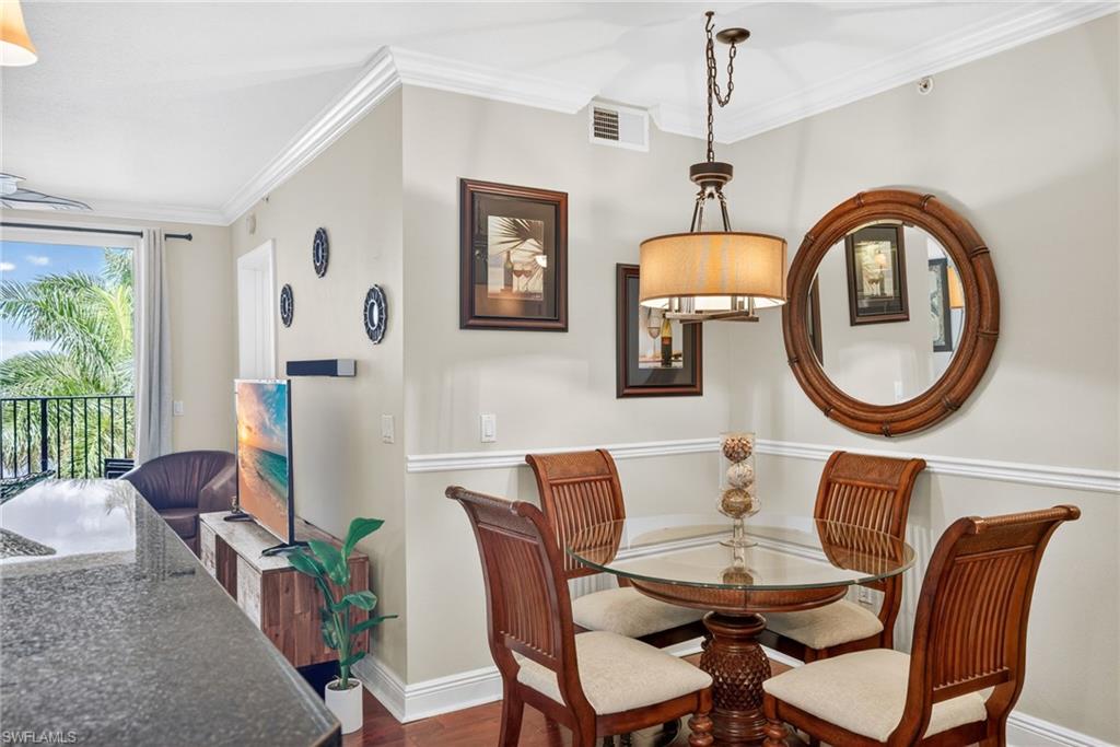 Dining area featuring crown molding and dark wood-style floors
