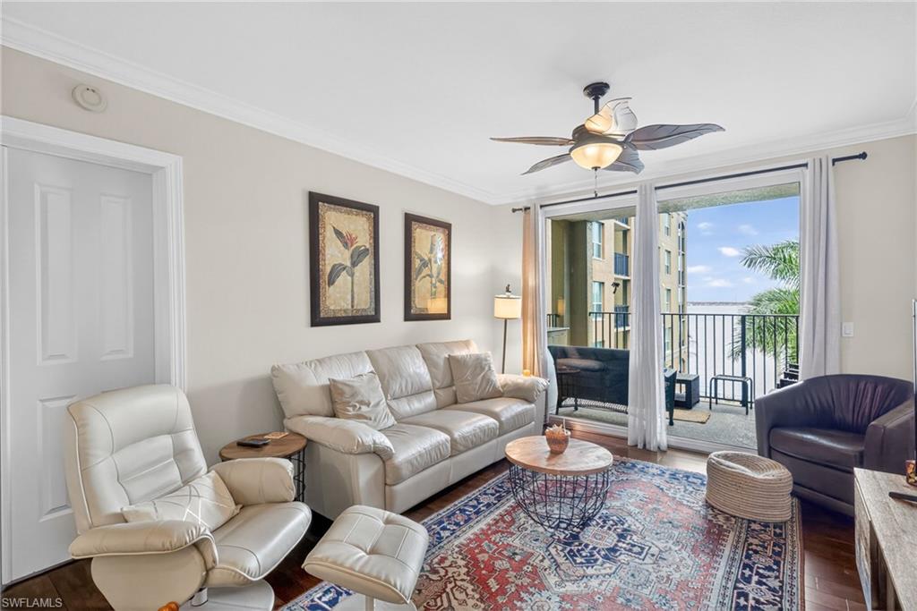 Living room featuring crown molding, wood finished floors, and a ceiling fan