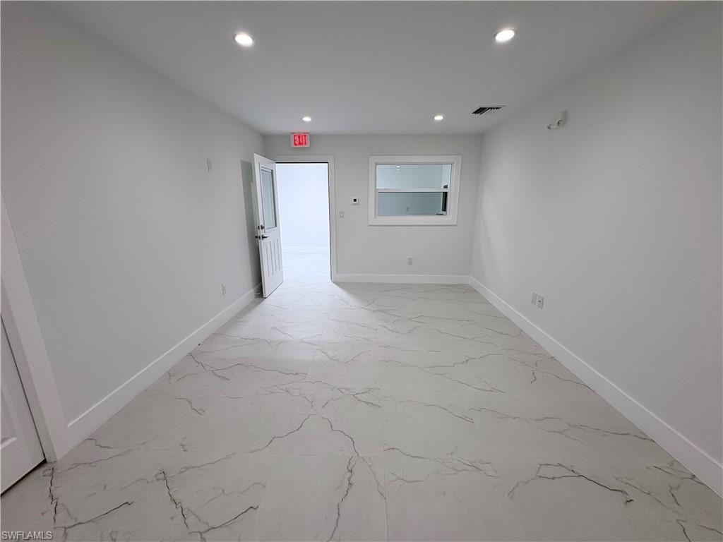 Unfurnished room featuring recessed lighting and light marble finish flooring