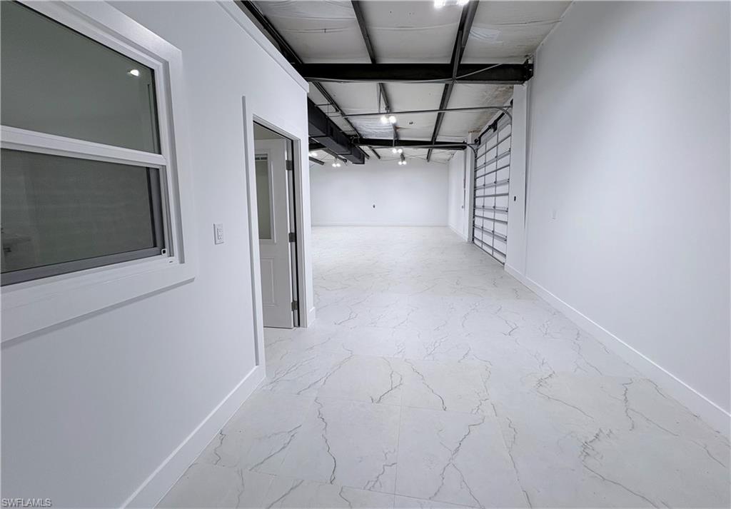 Corridor with baseboards and light marble finish floors