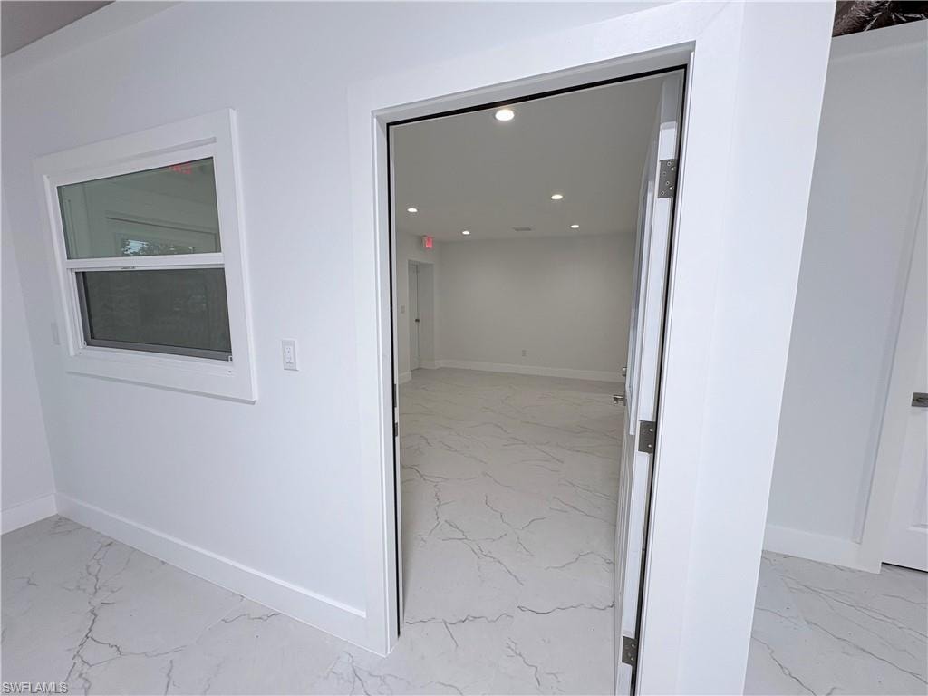 Hall featuring recessed lighting and light marble finish flooring