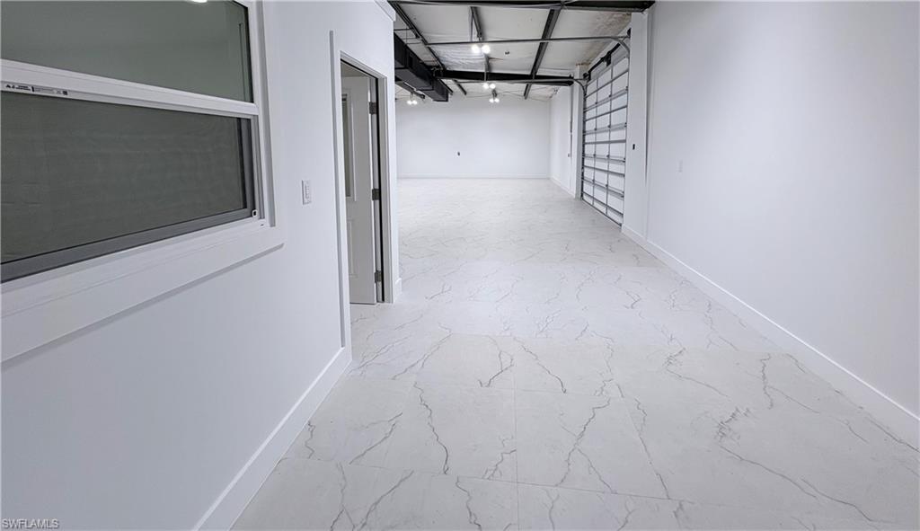 Corridor with baseboards and light marble finish flooring