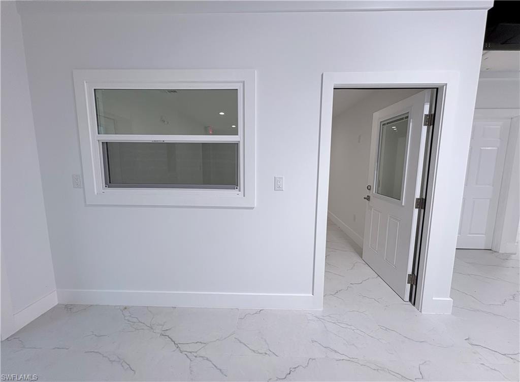Spare room with baseboards and light marble finish floors