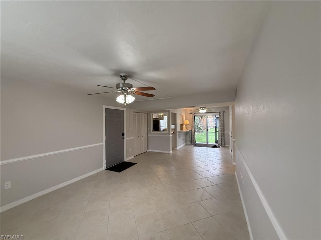 Unfurnished room featuring a ceiling fan and light tile patterned flooring
