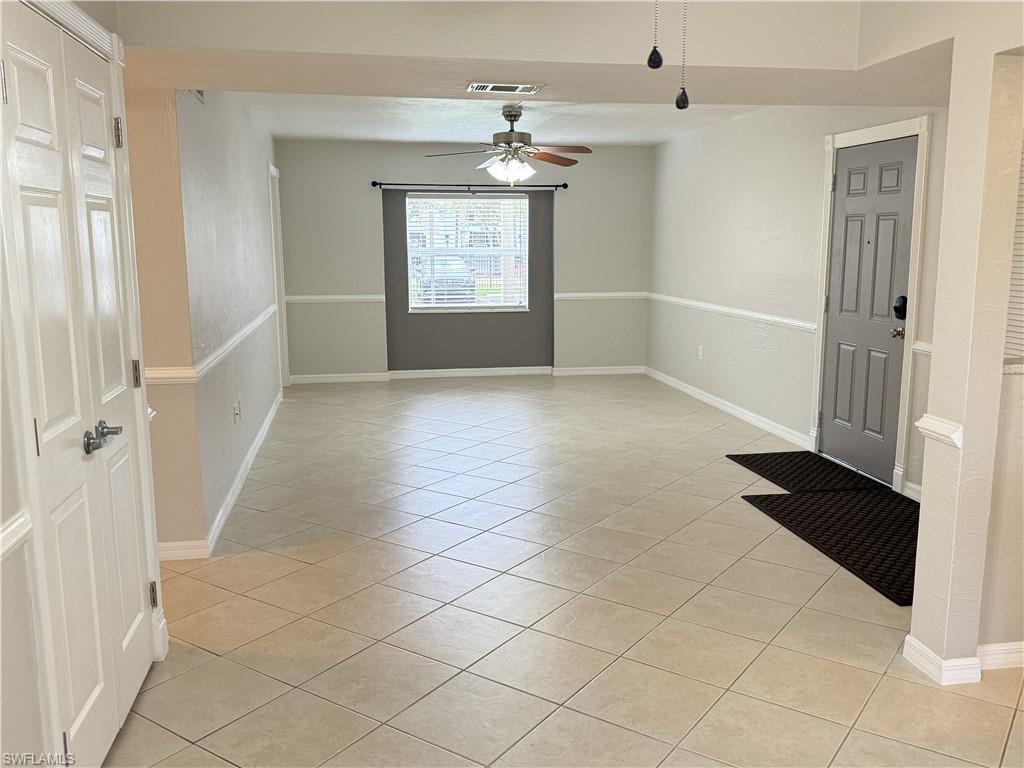 Dining area looking back to family room. Unfurnished room featuring light tile patterned floors and ceiling fan.