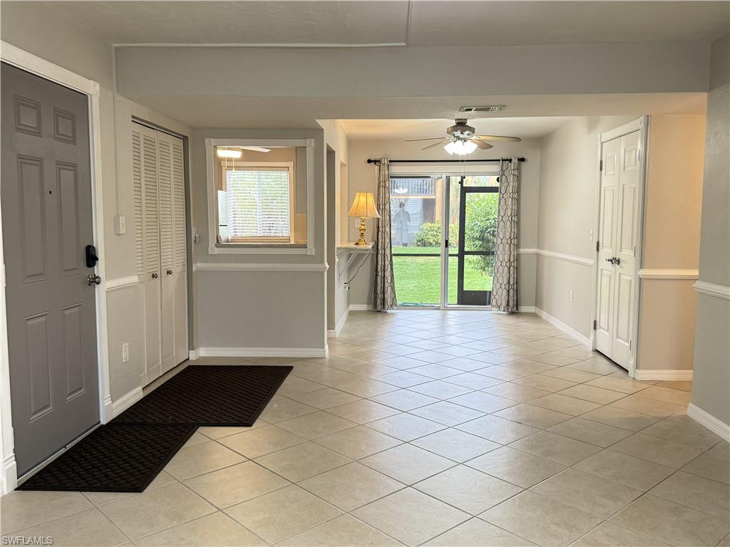Foyer/ Family area with light tile patterned floors and a ceiling fan