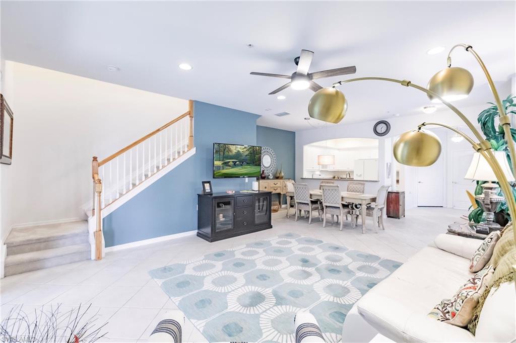 Living room featuring ceiling fan, arched walkways, recessed lighting, and light tile patterned floors