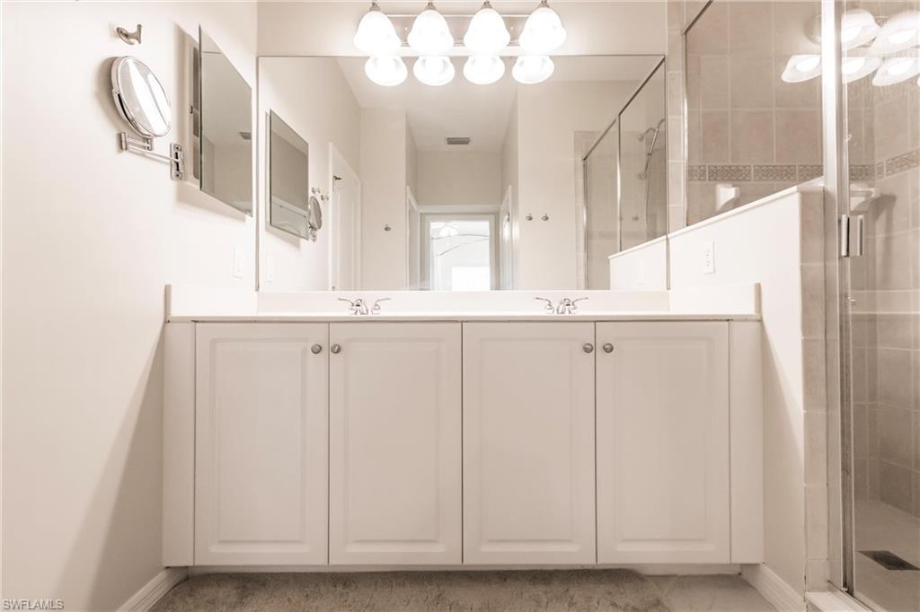 Full bathroom with a shower stall and double vanity
