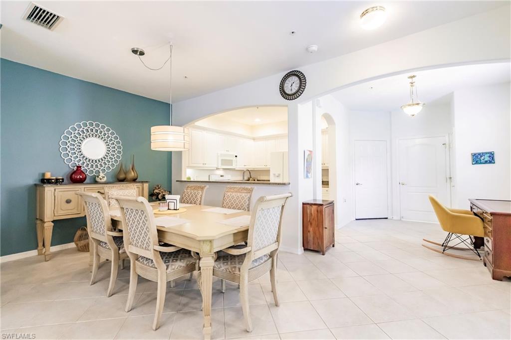 Dining room with arched walkways and light tile patterned floors