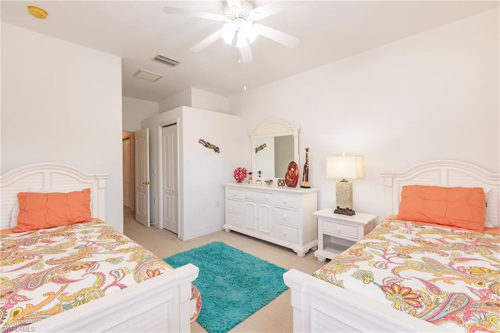 Bedroom with light carpet, ceiling fan, and a closet